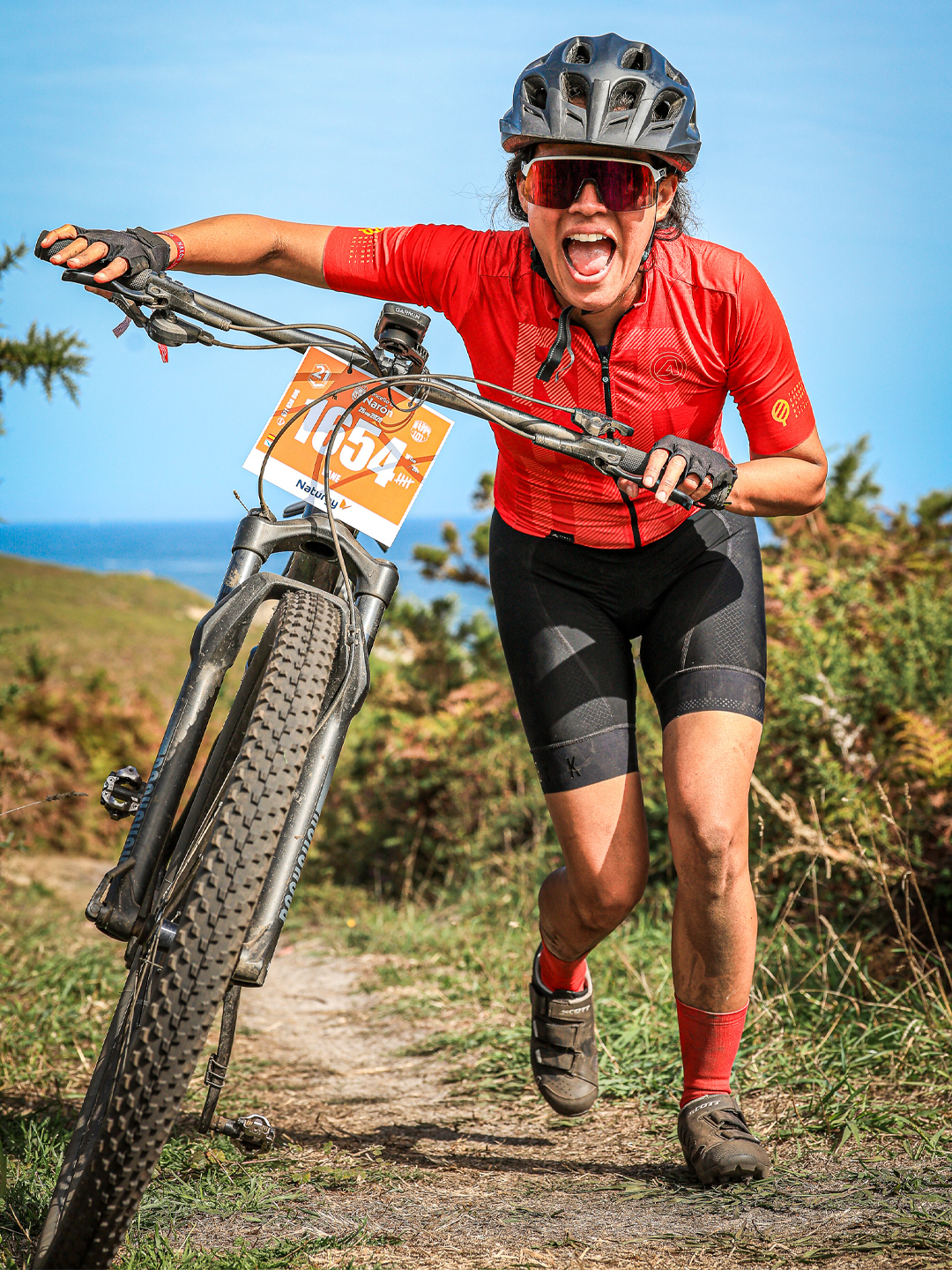 Mountain biker pushes her bicycle on the 21 Leguas Narón route