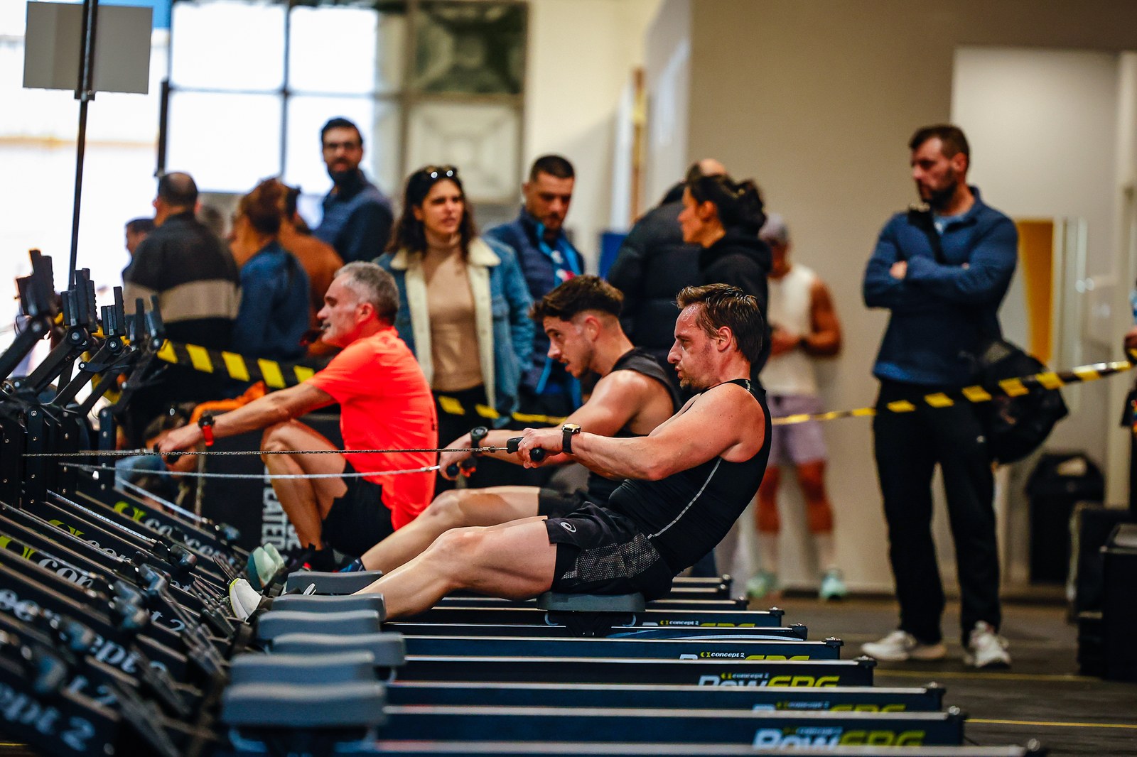 Competitors work through a rowing station in front of a crowd of spectators at the II Avynt Hyrox Simulation in Vila Nova de Gaia