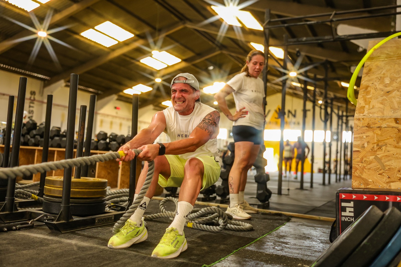 A competitor grits his teeth while pulling a weighted sled by rope at the III Avynt Hyrox Simulation in Vila Nova de Gaia