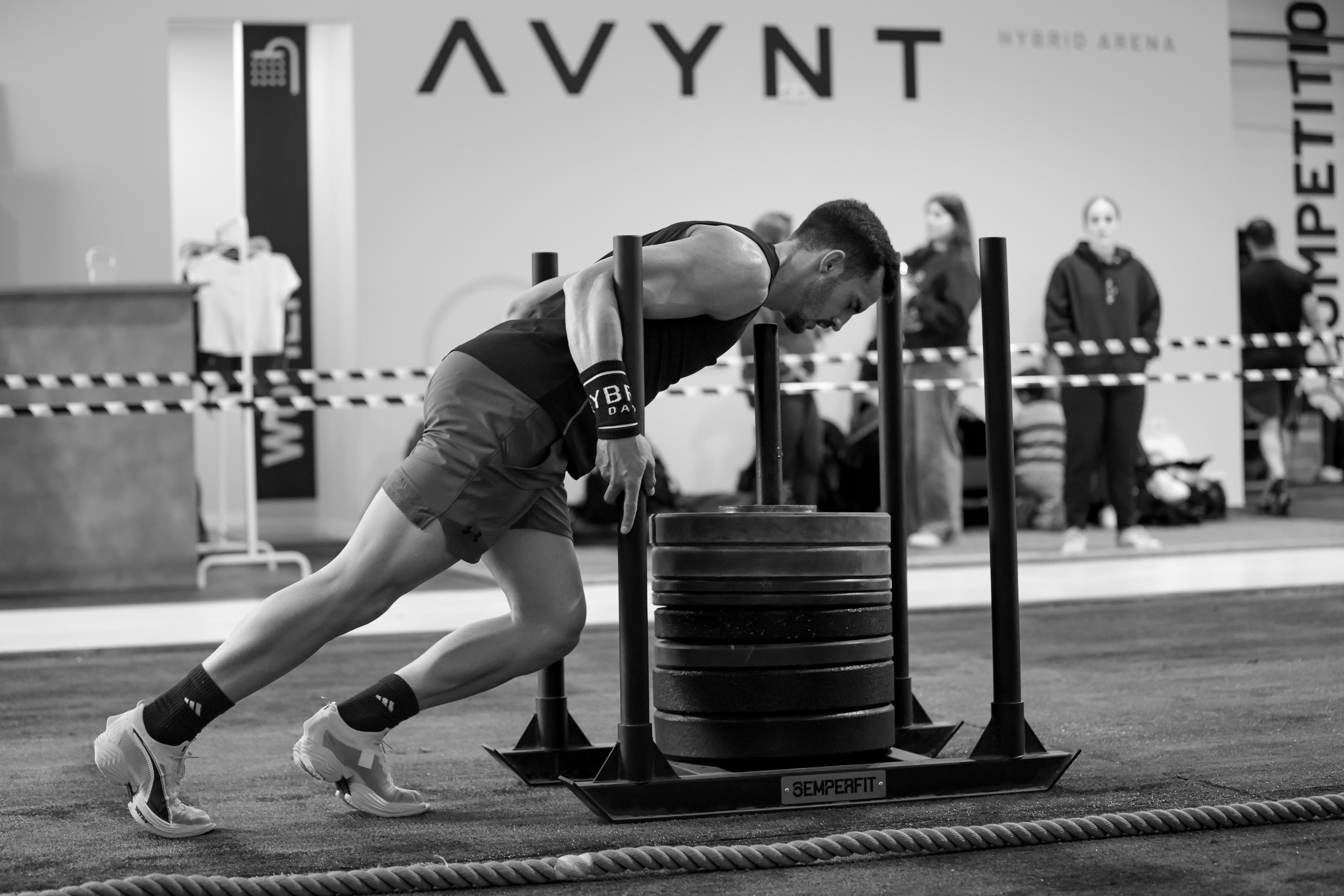 A competitor pushes a loaded sled during the AVYNT League's Hyrox-style stage one at AVYNT Hybrid Arena