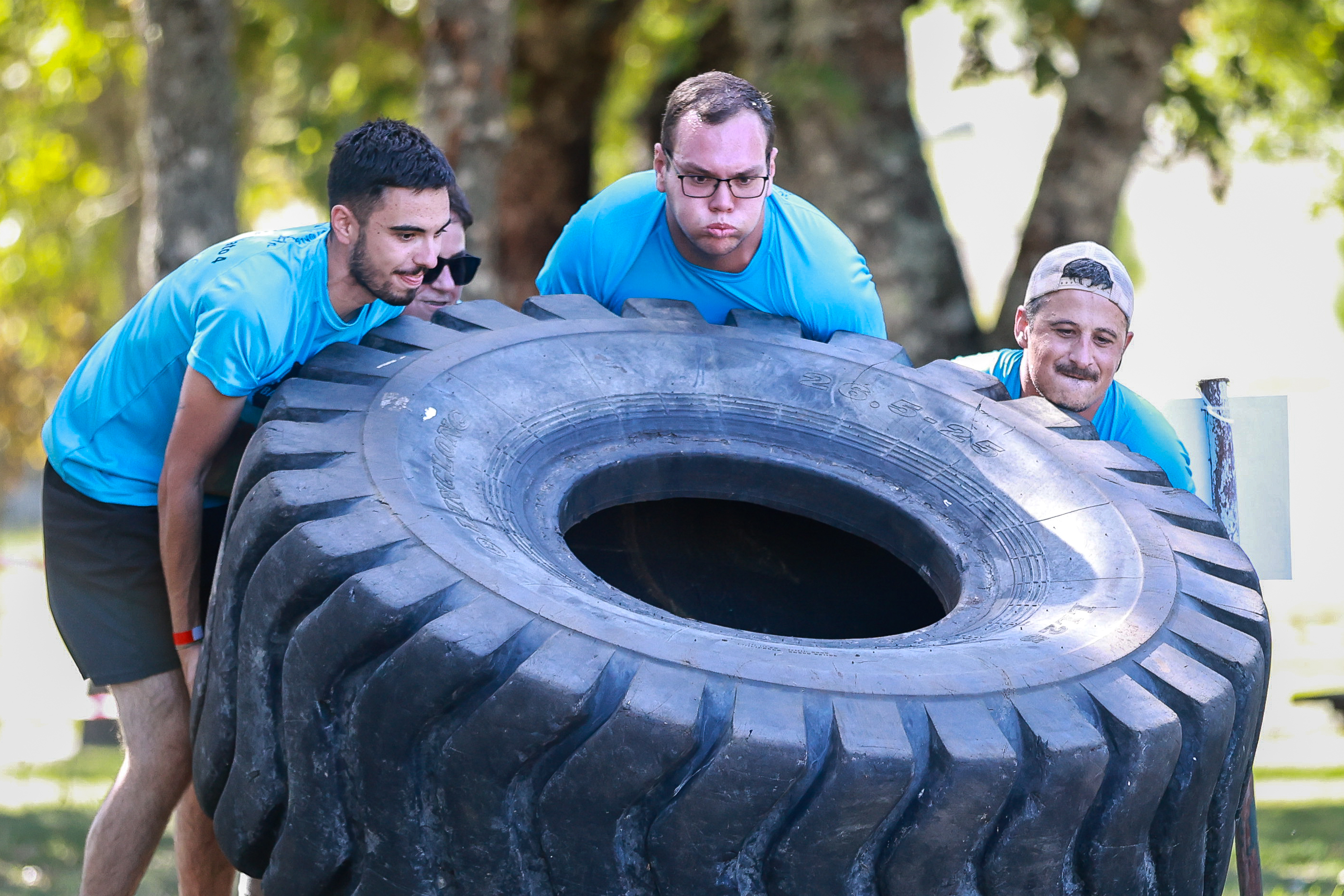 Participants lift a large tyre together at Barrelas Fire Challenge