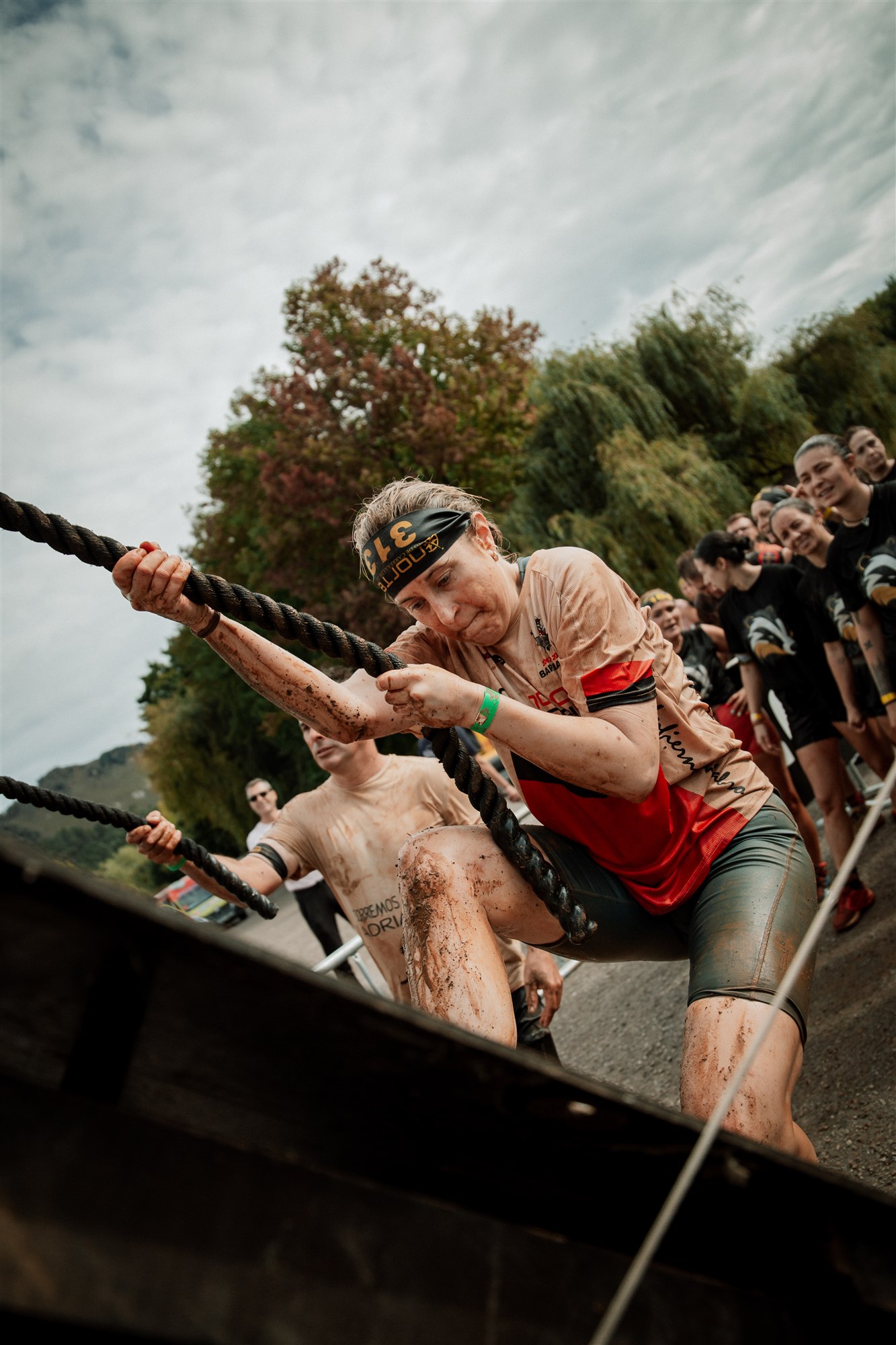 A Cabárceno Race participant pulls herself over a rope obstacle
