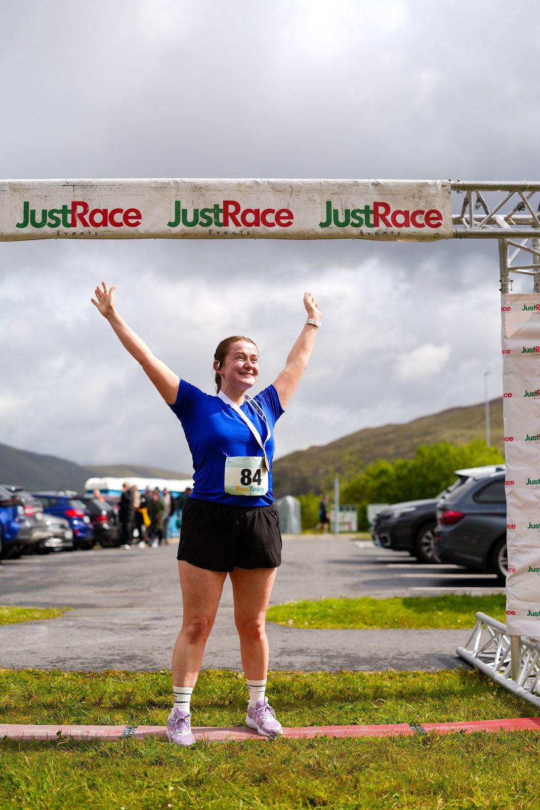 A runner celebrates crossing the finish line at the Delphi Half Marathon & 10K in Leenane