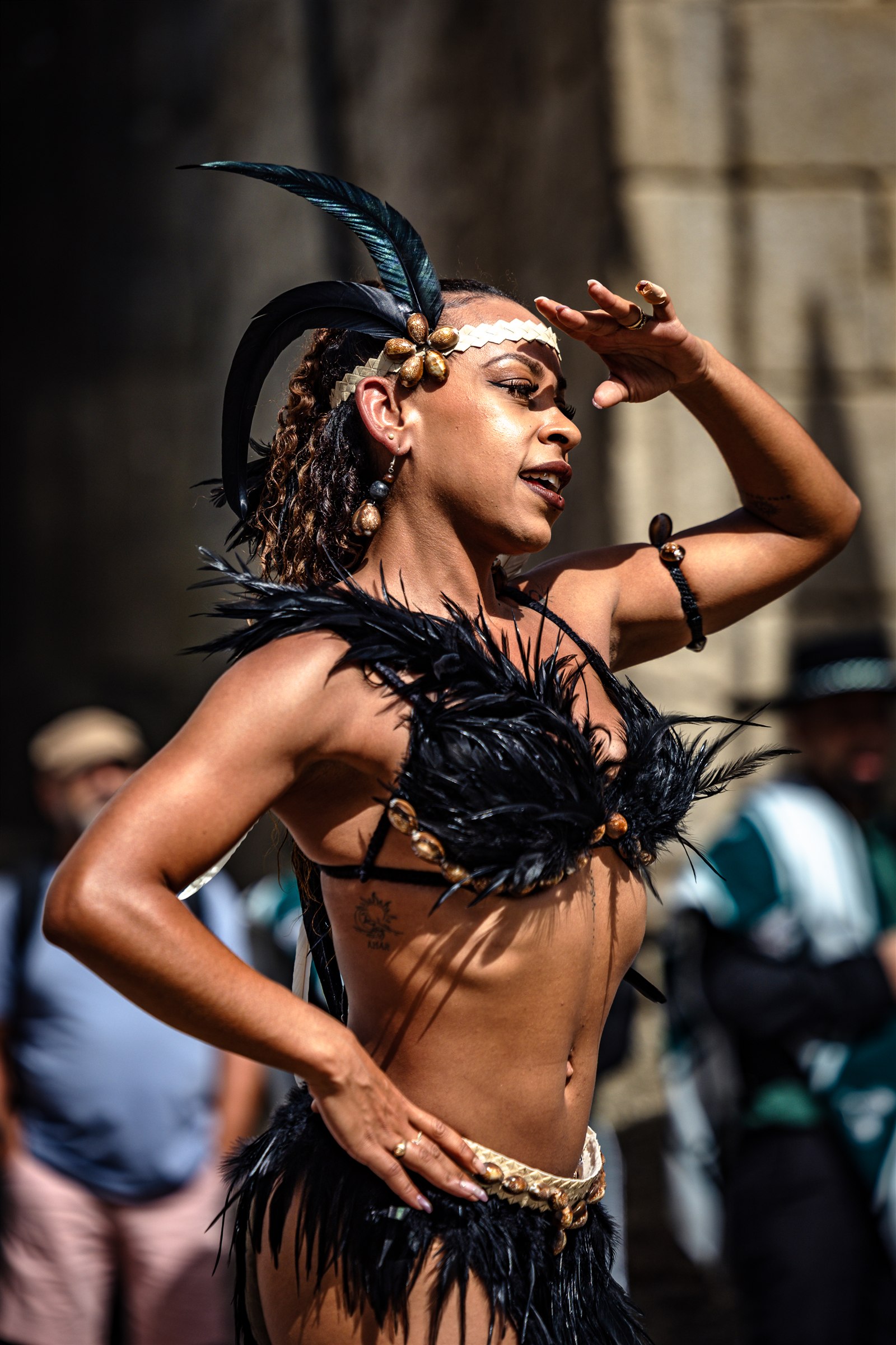 A performer in a feathered costume dances during Fest’In Folk Corredoura in Guimarães