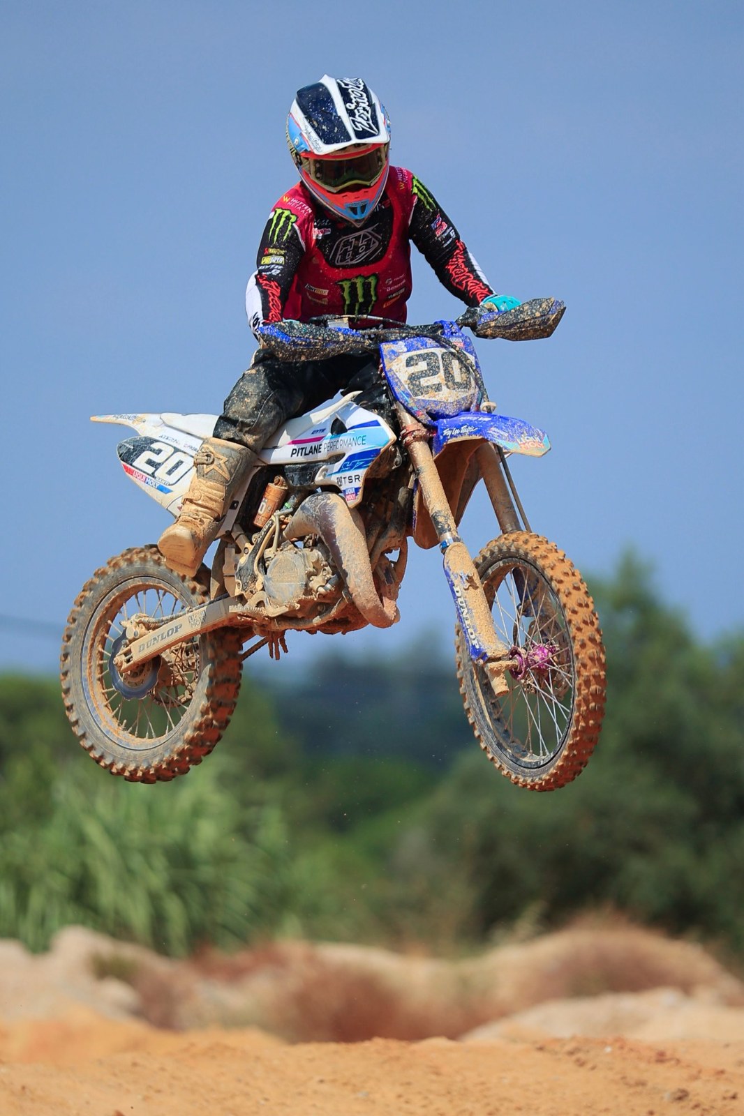 A rider in Monster Energy team colours clears a jump during the Fifty Party Motocross Experience in Pontes