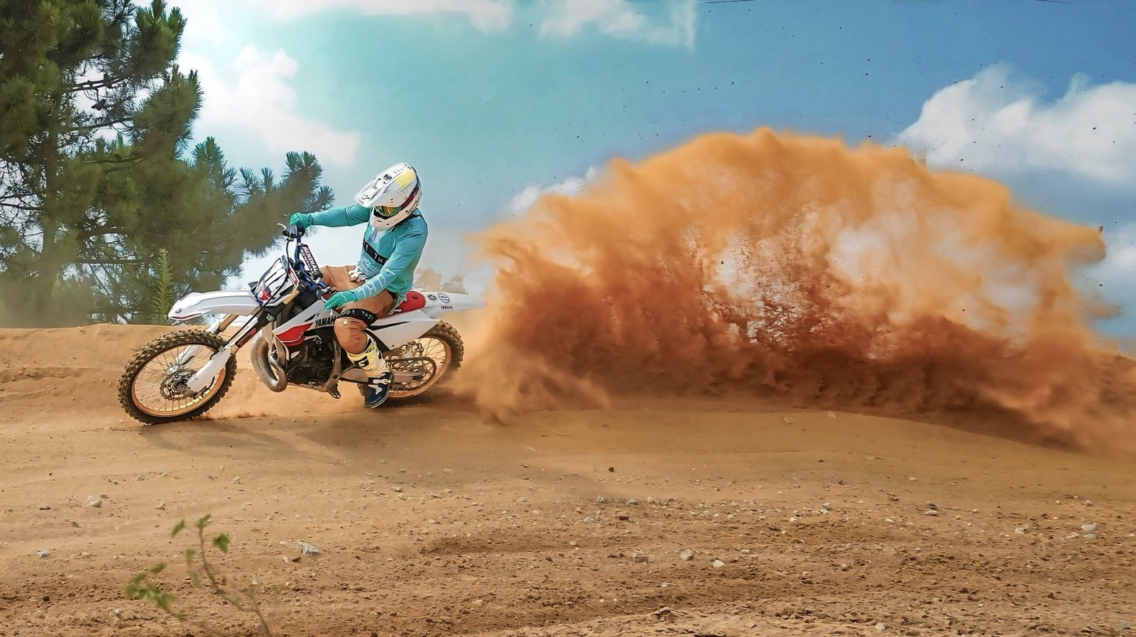 A motocross rider throws up a wall of dust sliding through a corner during the Fifty Party Motocross Experience in Pontes