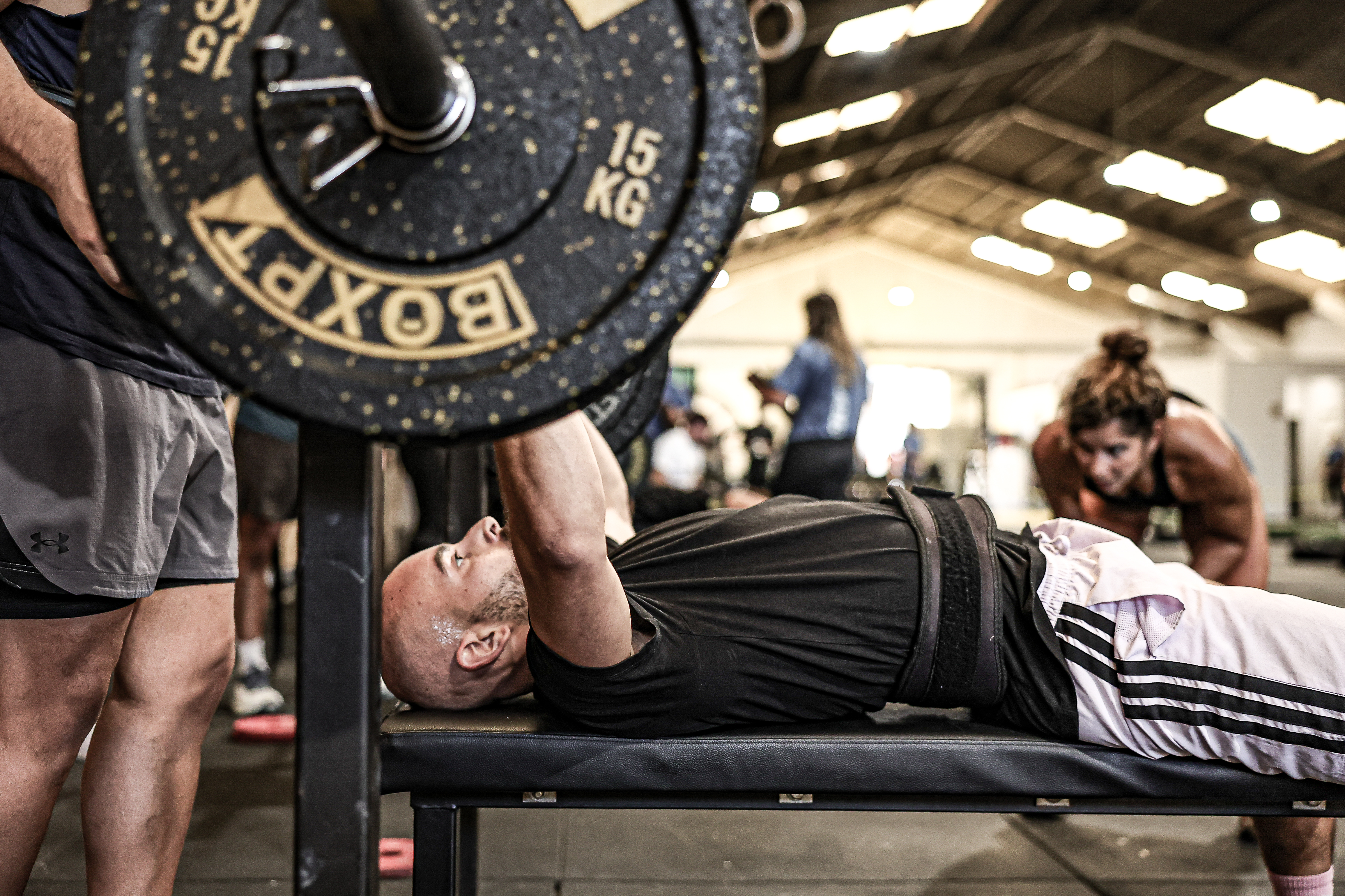 A competitor performs a bench press during Fusion Games