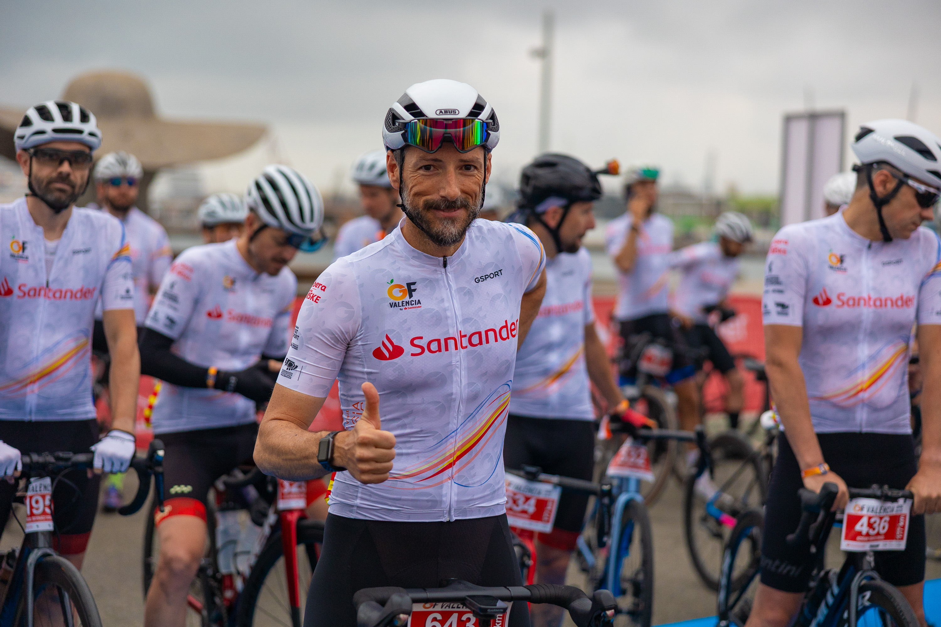 Cyclists at the Gran Fondo València start line in Santander team jerseys