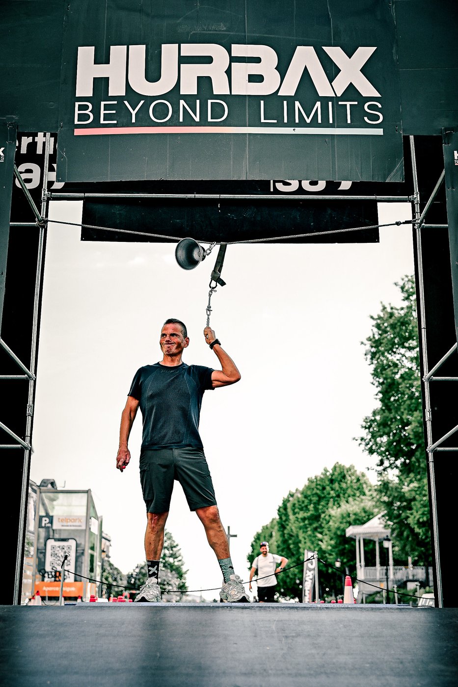 An athlete ringing the bell at the Hurbax Pontevedra finish arch