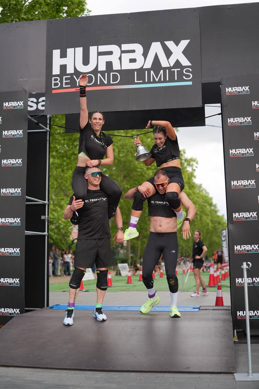 Team members celebrate crossing the Hurbax Beyond Limits finish arch in Santander