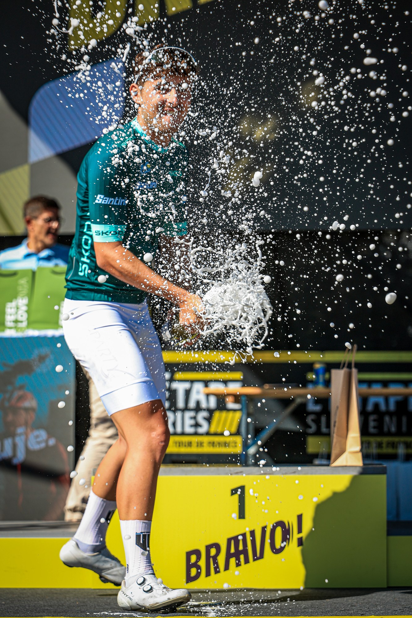 The L’Étape Slovenia winner sprays champagne during the podium celebration in Kranj
