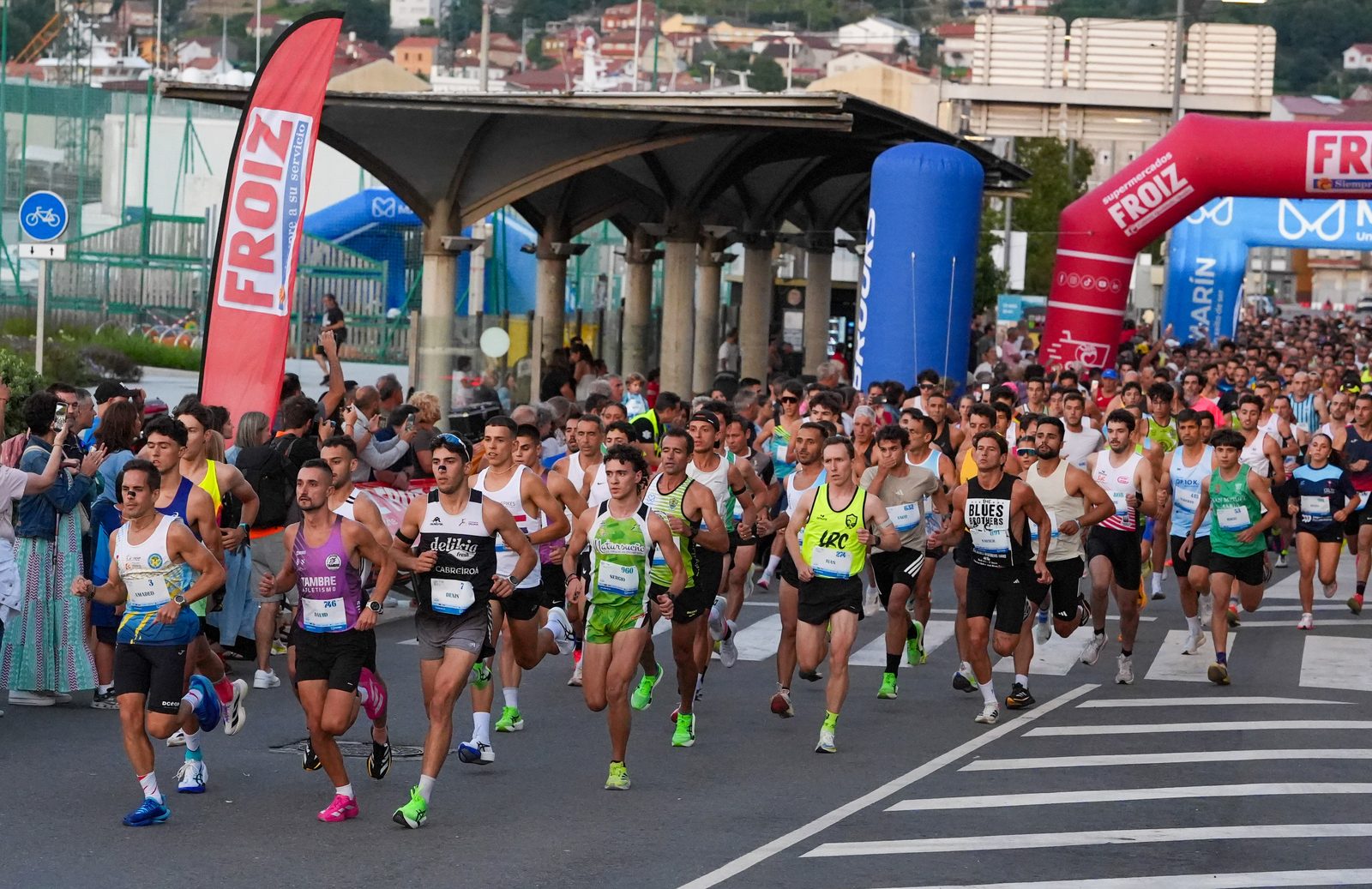 A dense pack of runners sets off past the FROIZ arch at the start of the Manuel Rosales +10 Marín