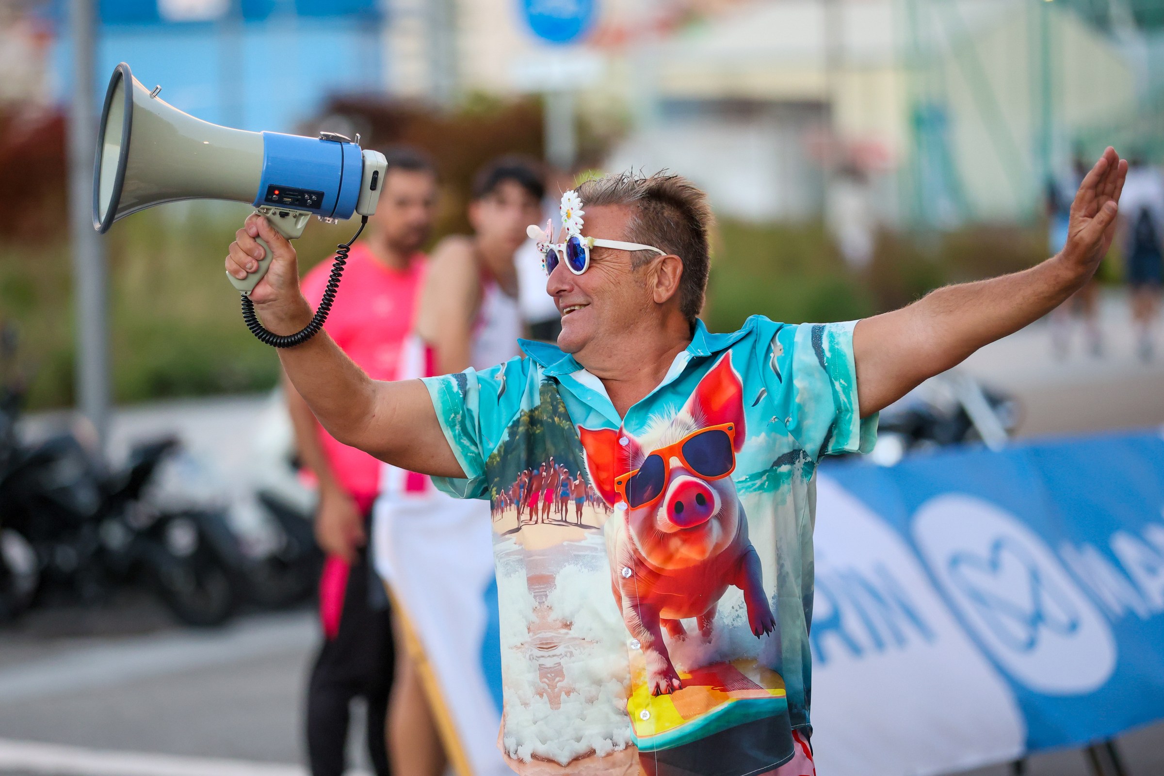 An event entertainer raises a megaphone and greets the crowd in Marín