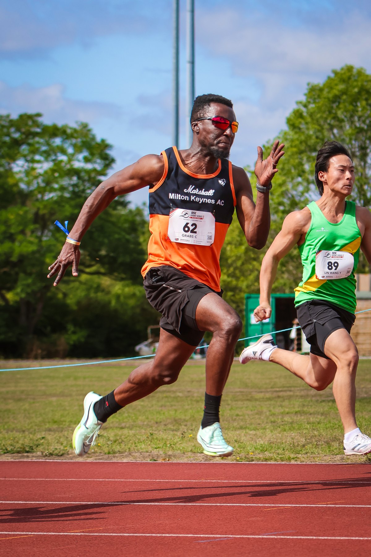 Two athletes sprint side by side at Stantonbury Stadium during MK Sprint Series 3