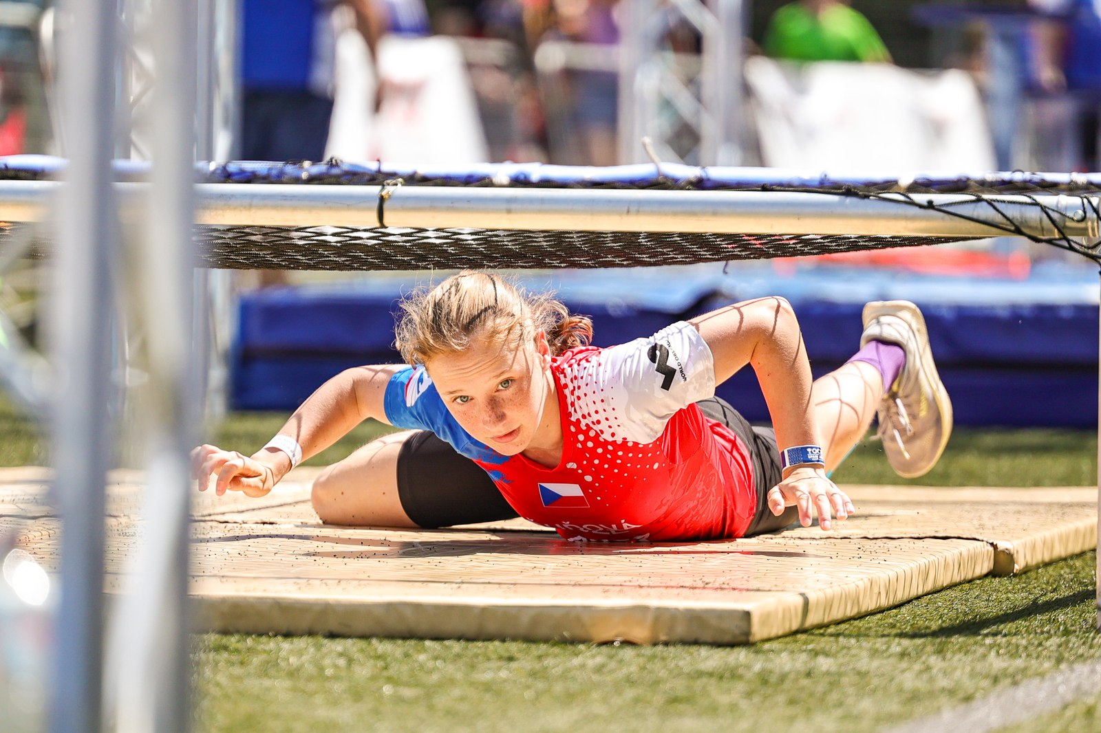 A competitor negotiates a net-crawl obstacle during the OCR European Championships in Irun