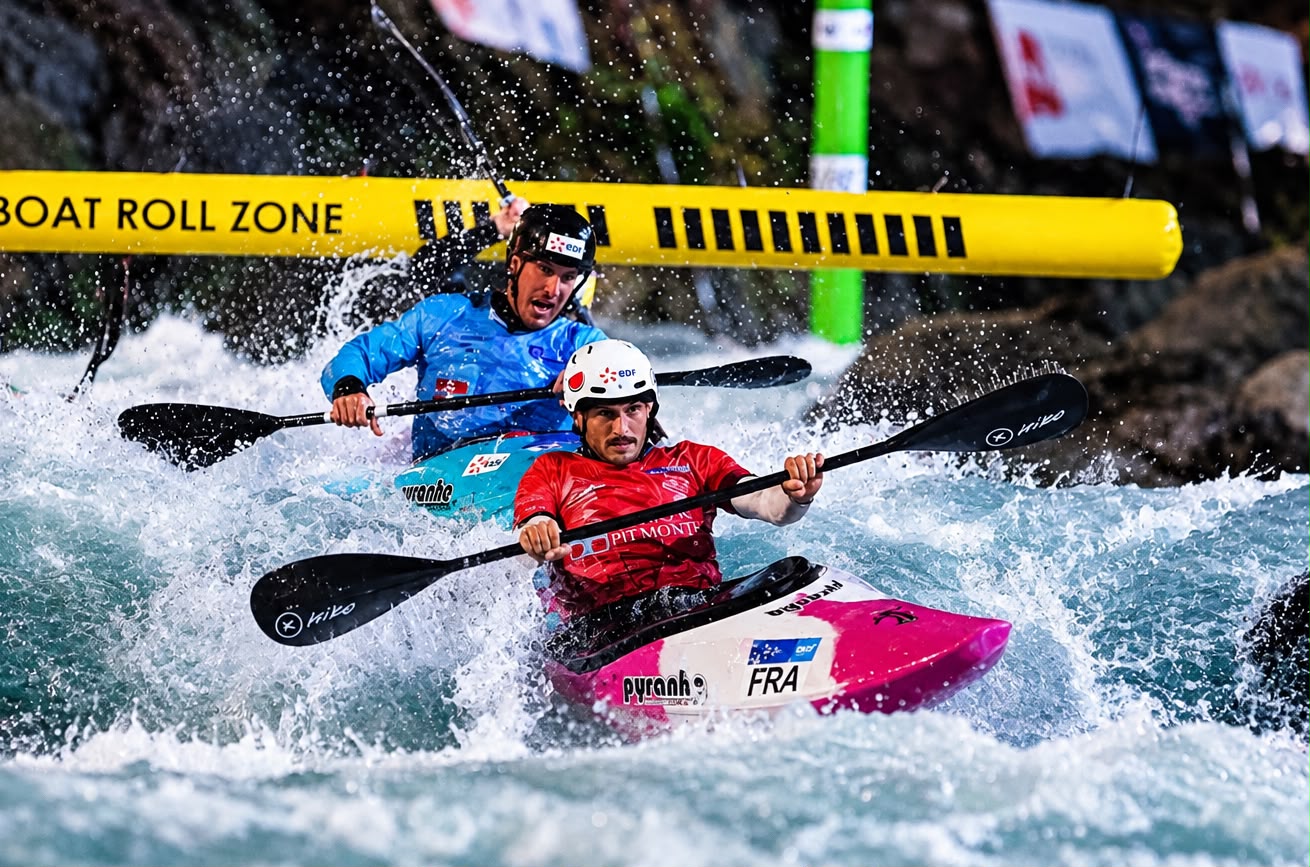 Two canoe slalom athletes charge through whitewater at the 2026 European Championships in Ivrea