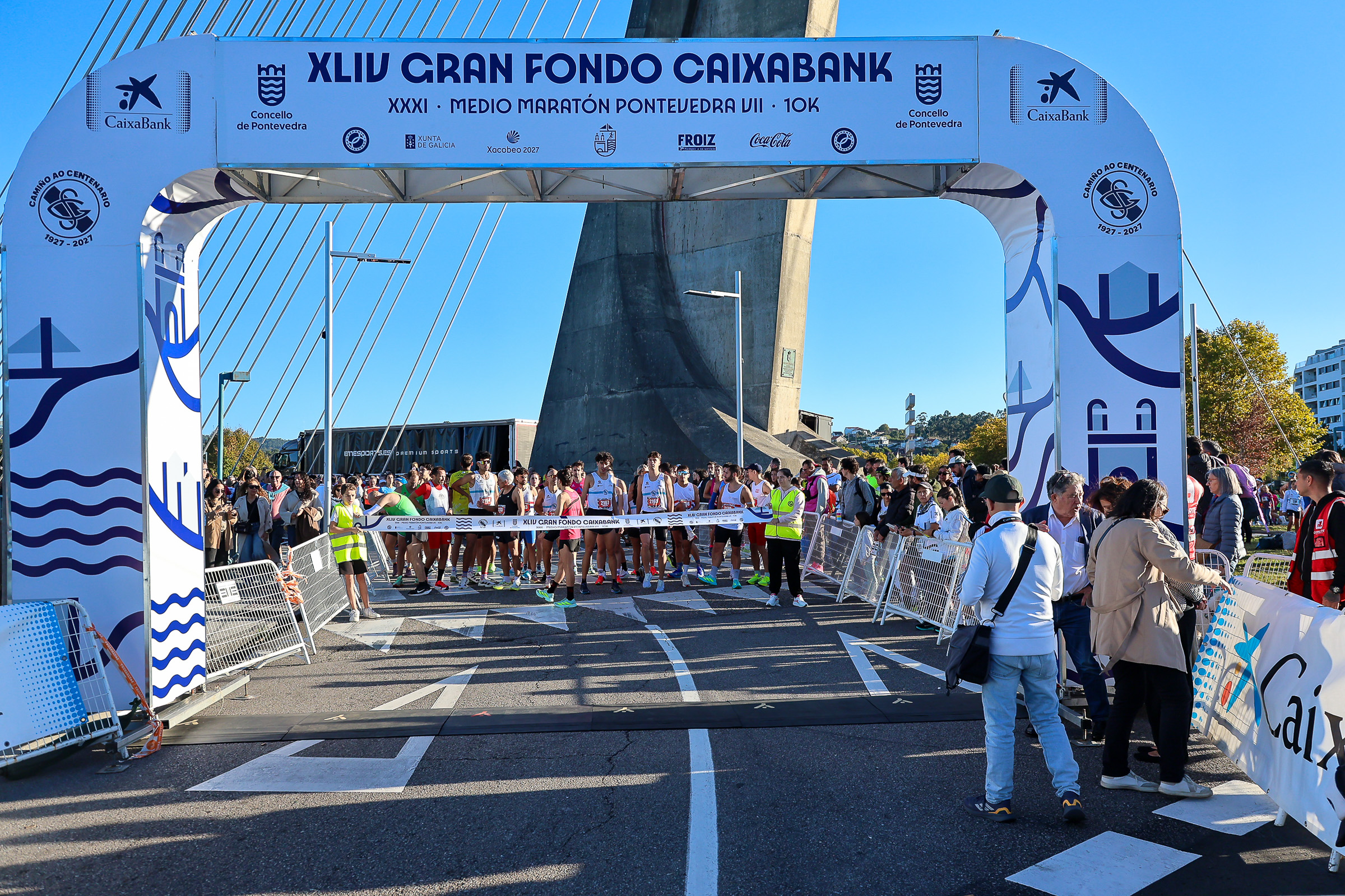 Runners beneath the XLIV Gran Fondo CaixaBank start arch