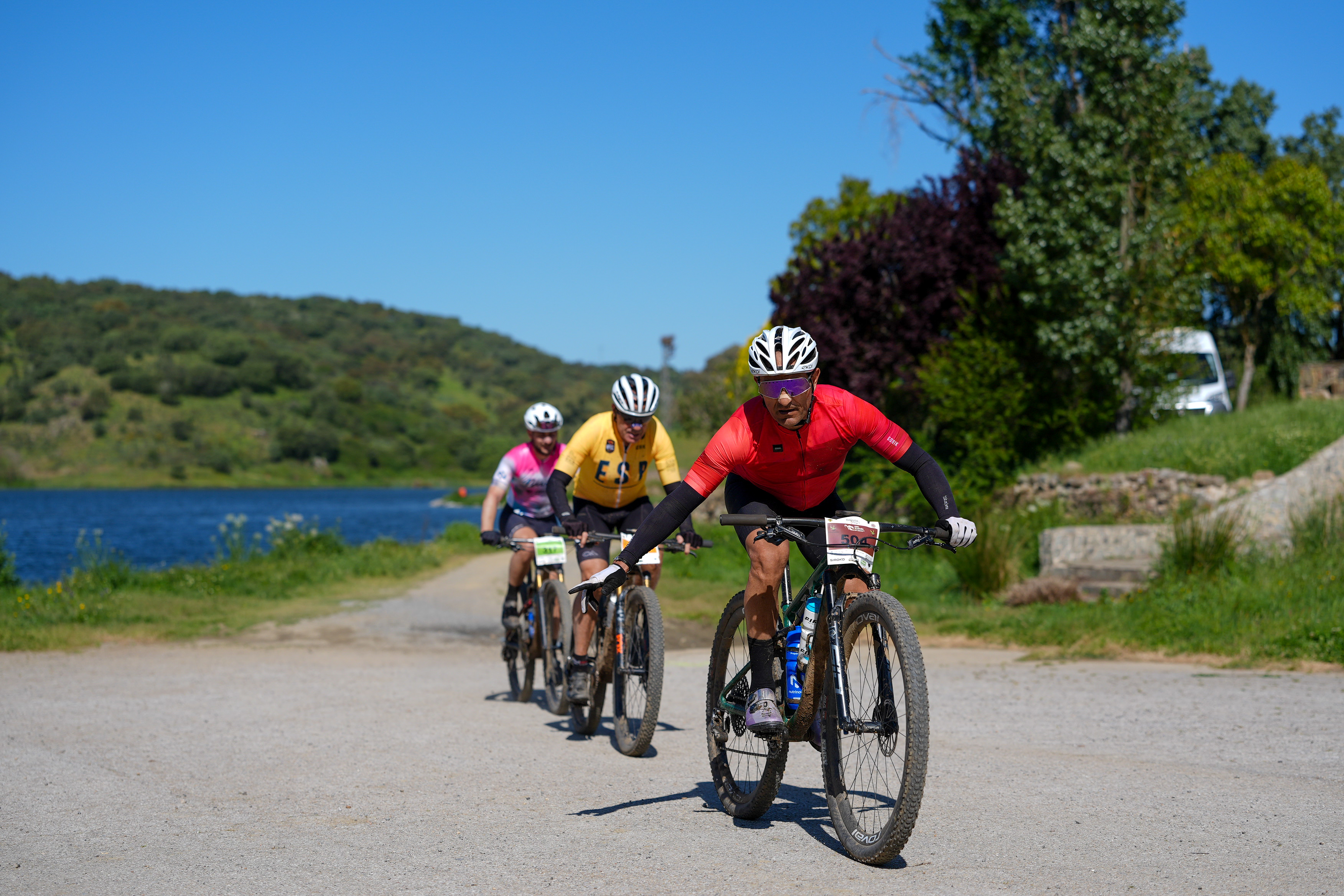Riders passing a reservoir during the Preeuropeo Templarios MTB Race near Jerez de los Caballeros