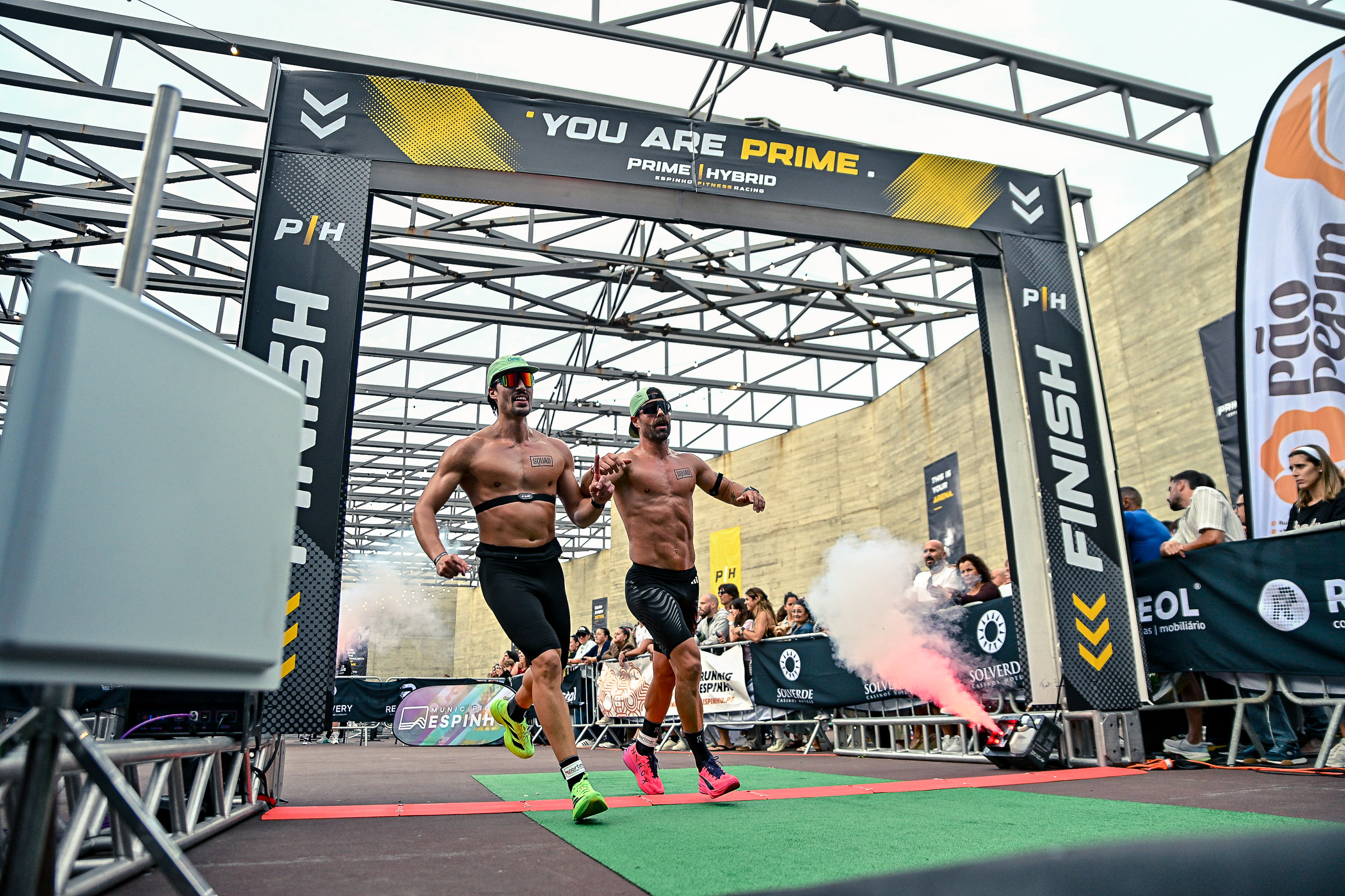 Two athletes cross the finish line together beneath the Prime Hybrid arch in Espinho