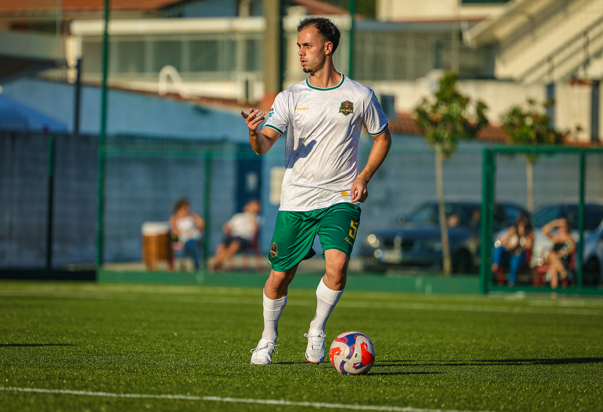 Player in white and green beside the ball at SOCCA Porto