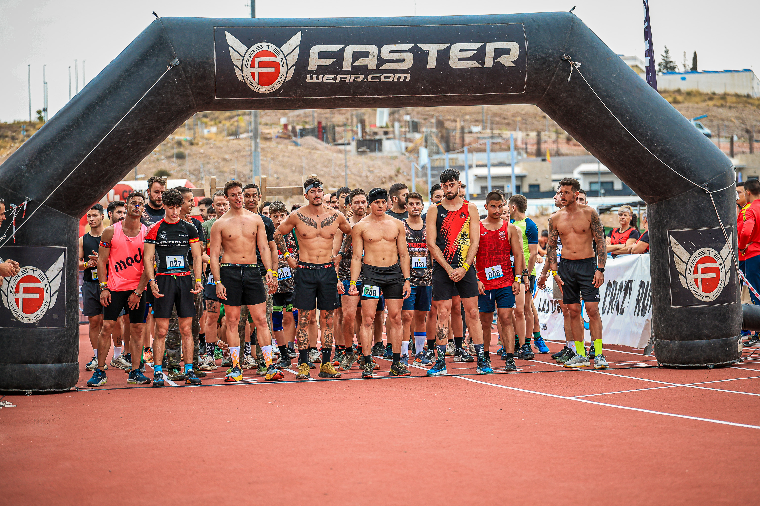 Tercios Legendarios competitors gather beneath the start arch in Alcantarilla