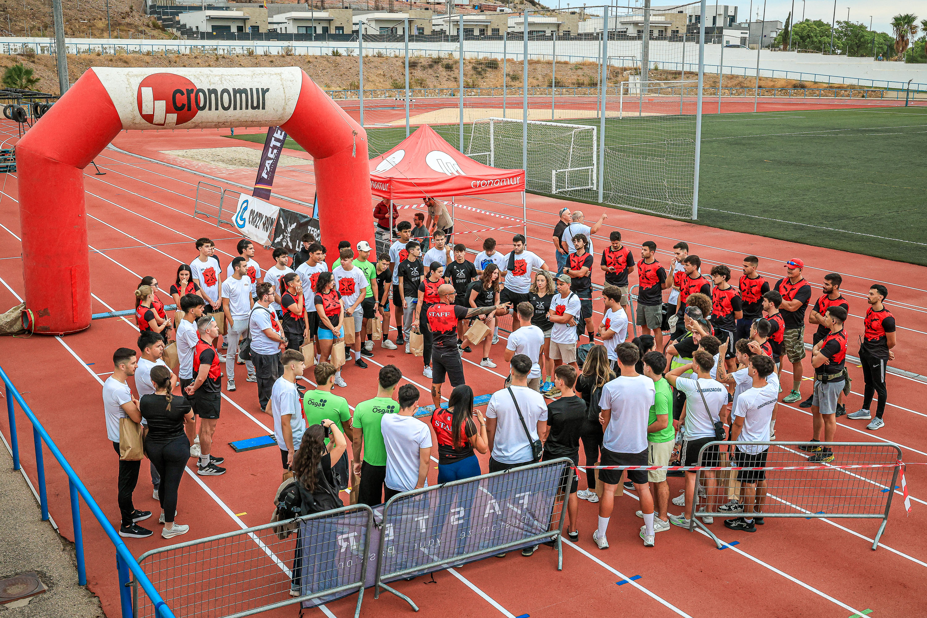 Tercios Legendarios staff and volunteers work beside the athletics track