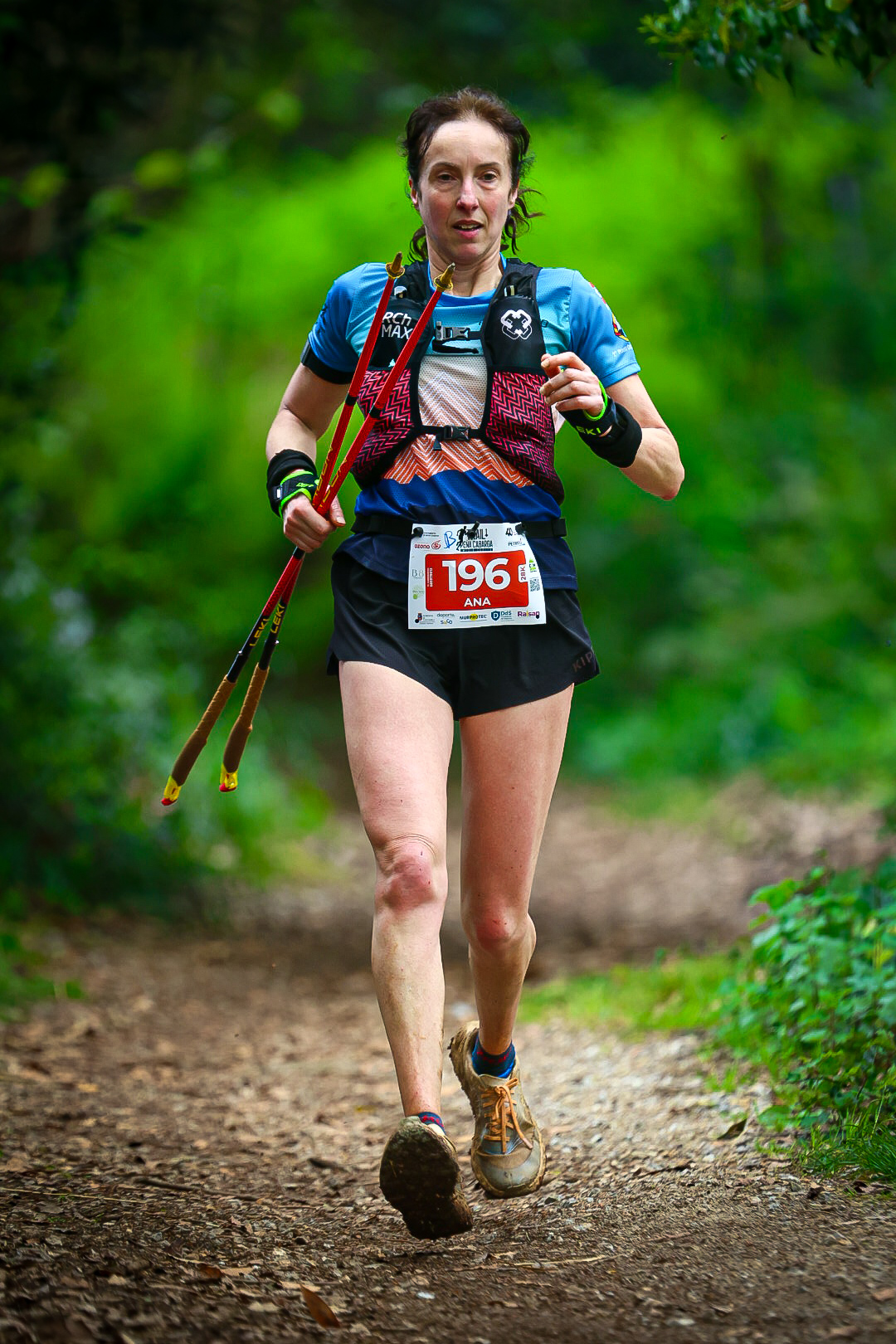 Female trail runner competing on a wooded section of Trail Peña Cabarga