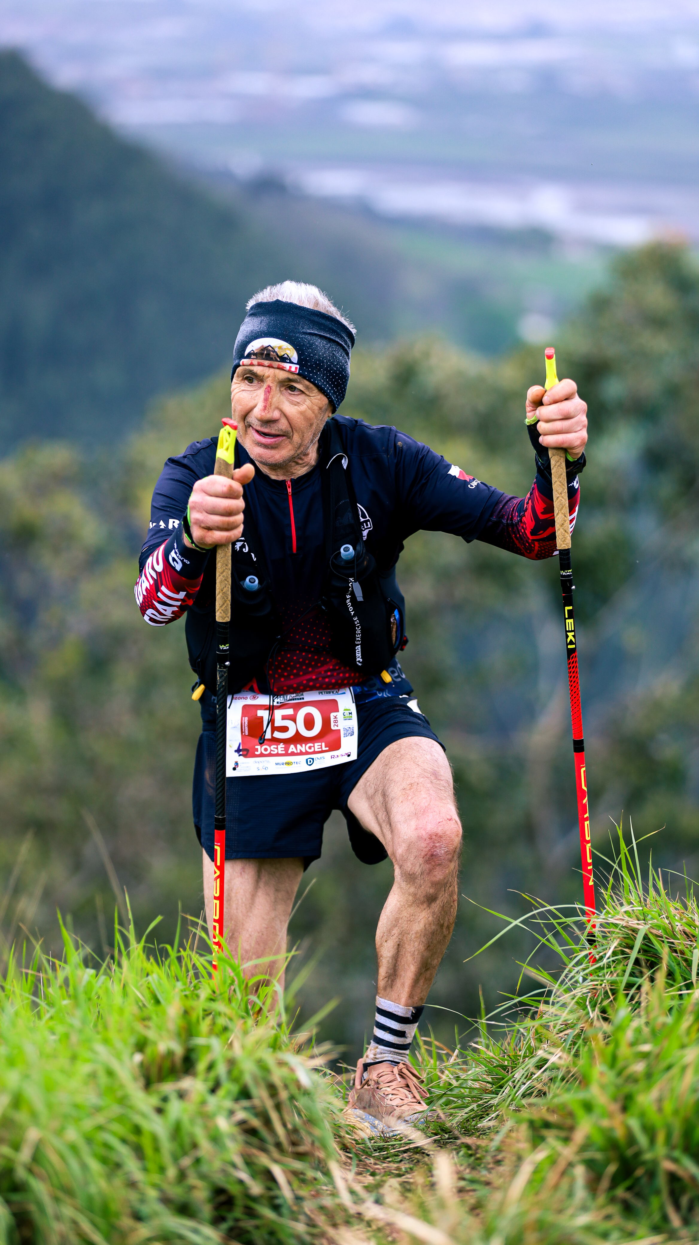 Trail runner climbing with poles during Trail Peña Cabarga