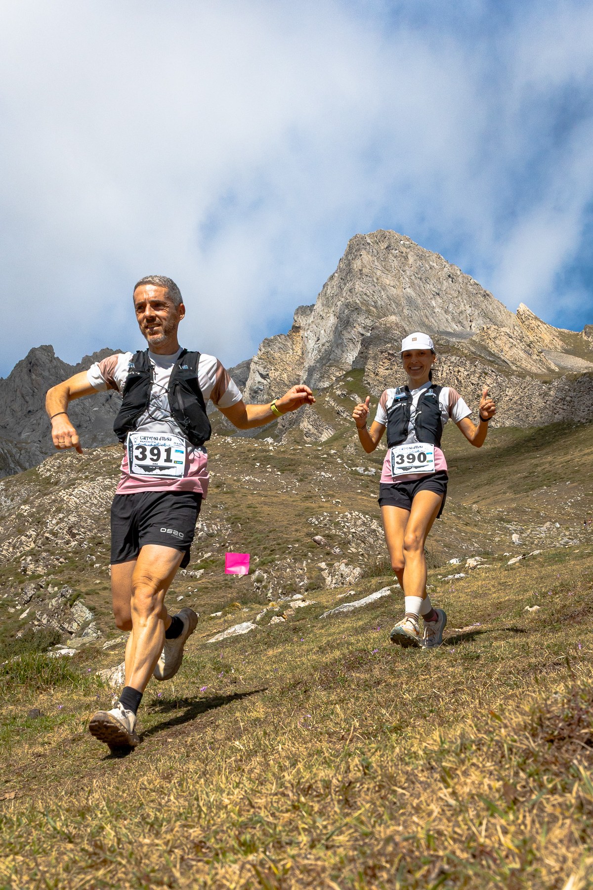 Two trail runners descend beneath a rocky peak during the 2026 Trail de Ubiña