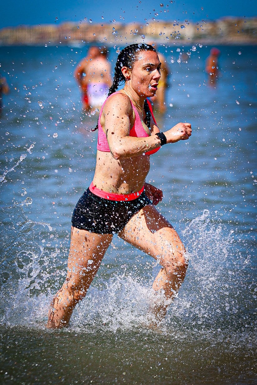An athlete runs through the water during the Trident Battle open-water trial in Nettuno