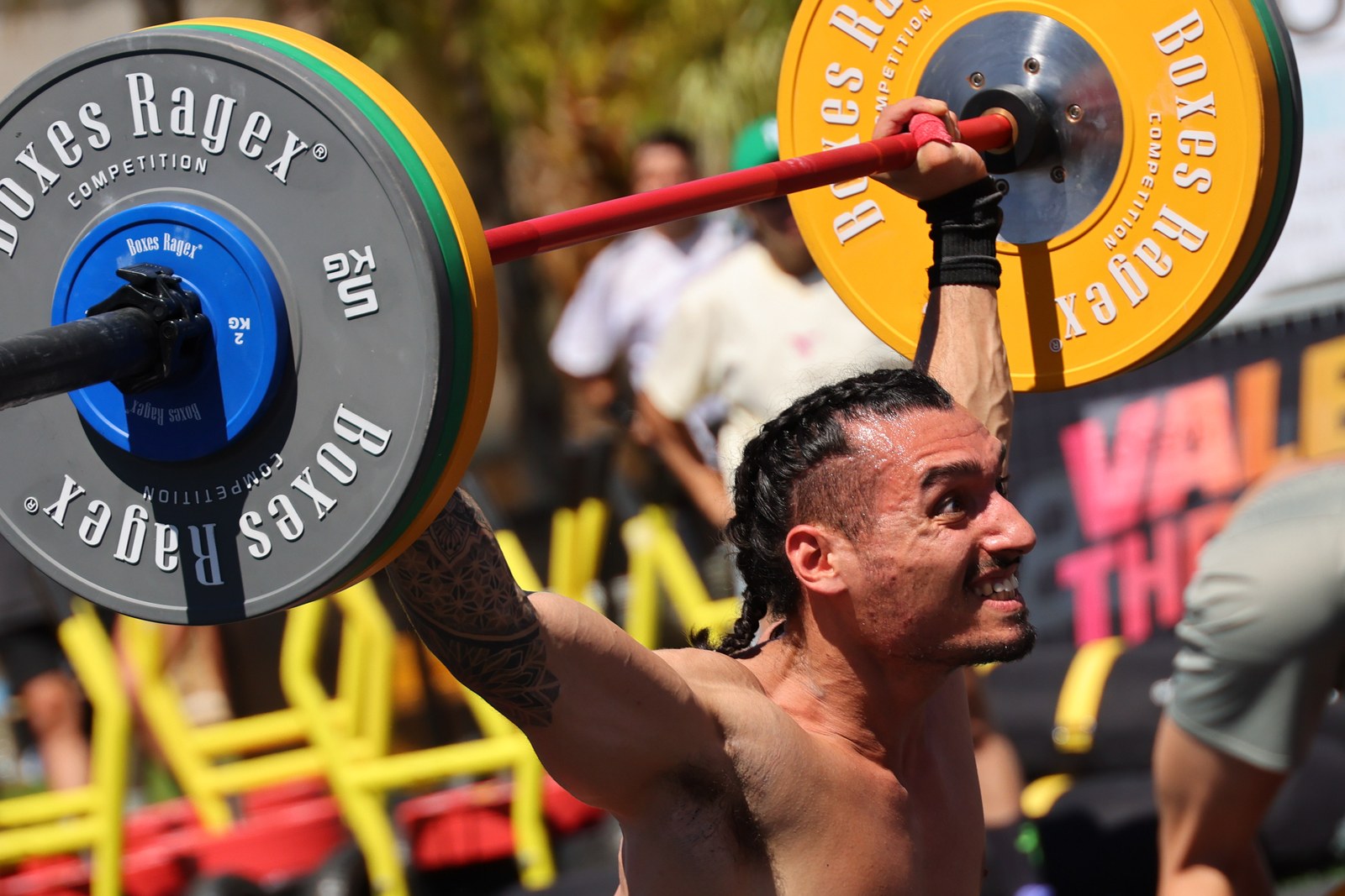 An athlete locks out an overhead barbell lift at the Valencia Throwdown